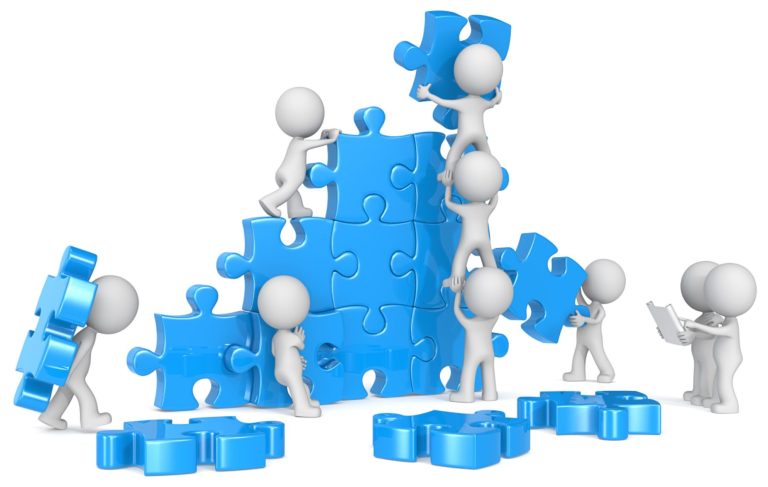Bonhommes travaillant en équipe pour construire un puzzle